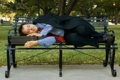 Businessman napping on park bench